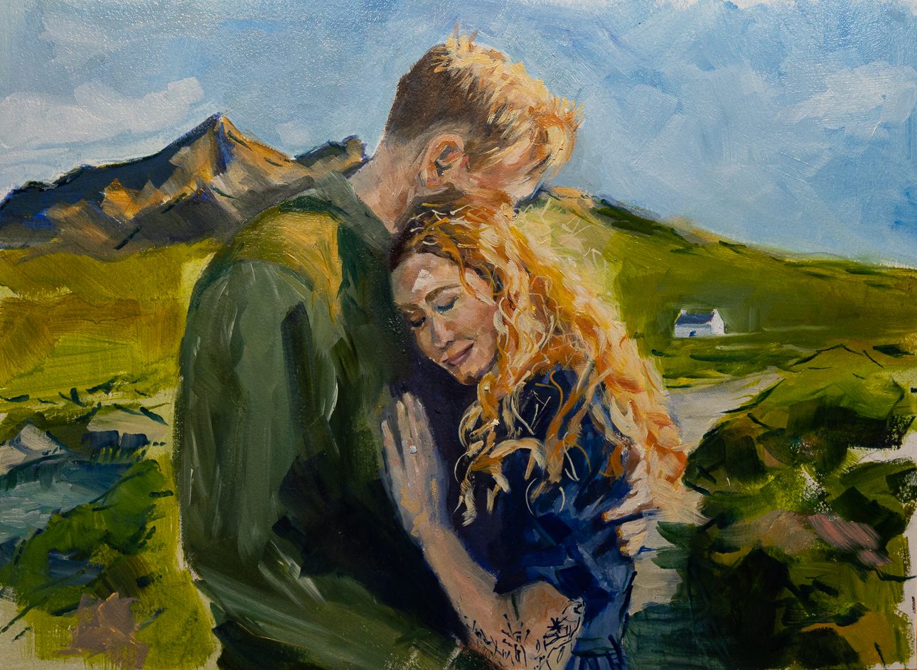 Couple painting Sligachan Isle of Skye. Couple with red hair embrace in foreground with Cuillin and white cottage in background. Bride wears blue dress and has intricate arm tattoo